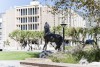 A statue of a coyote howling in the quad in front of Pfau Library on the CSUSB campus